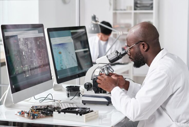 [fpdl.in]_young-serious-african-man-with-microscope-sitting-by-workplace_274679-31506_medium
