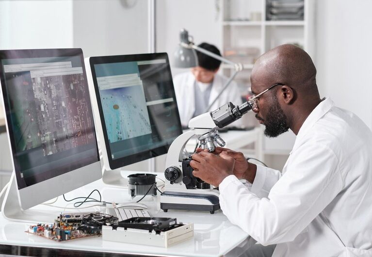 [fpdl.in]_young-serious-african-man-with-microscope-sitting-by-workplace_274679-31506_medium